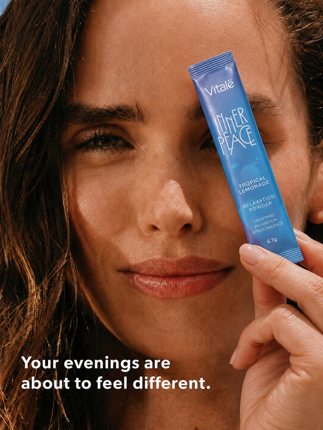 Woman holding a Vitalë Inner Peace Tropical Lemonade stick pack beside her face